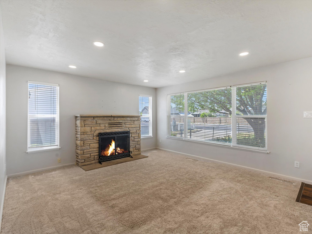 Unfurnished living room featuring carpet flooring, baseboards, and recessed lighting