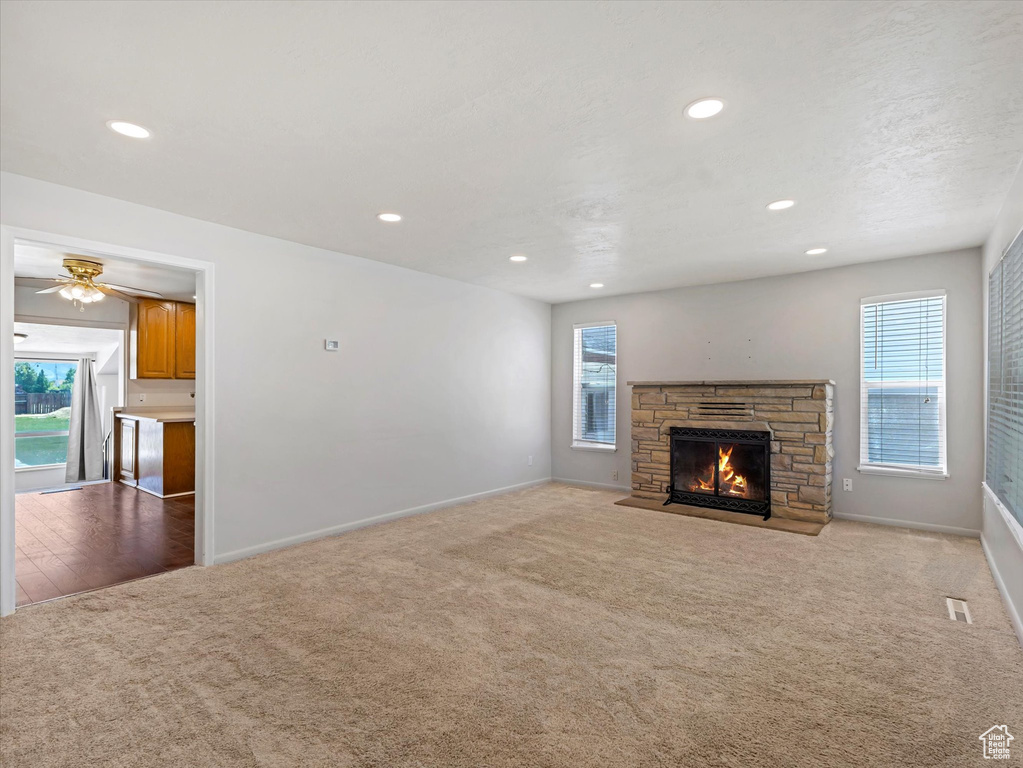 Unfurnished living room featuring carpet flooring, baseboards, a fireplace, recessed lighting, and ceiling fan