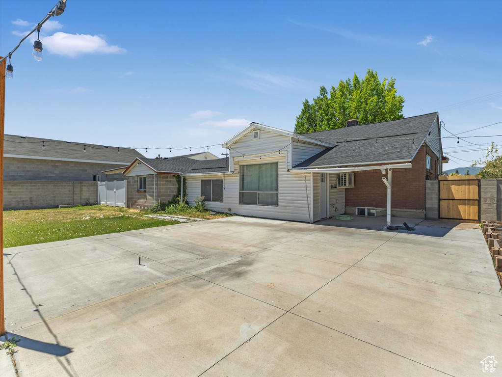 Back of property with a gate and roof with shingles