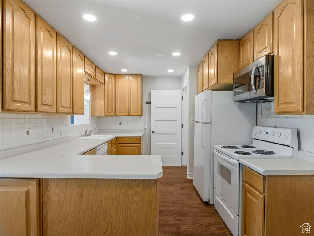 Kitchen with stainless steel microwave, white range with electric stovetop, a sink, dark wood finished floors, and recessed lighting