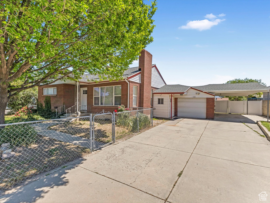 View of front of property with brick siding, a fenced front yard, and a gate