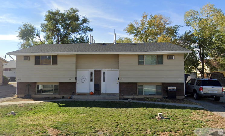 Bi-level home featuring a front lawn and brick siding