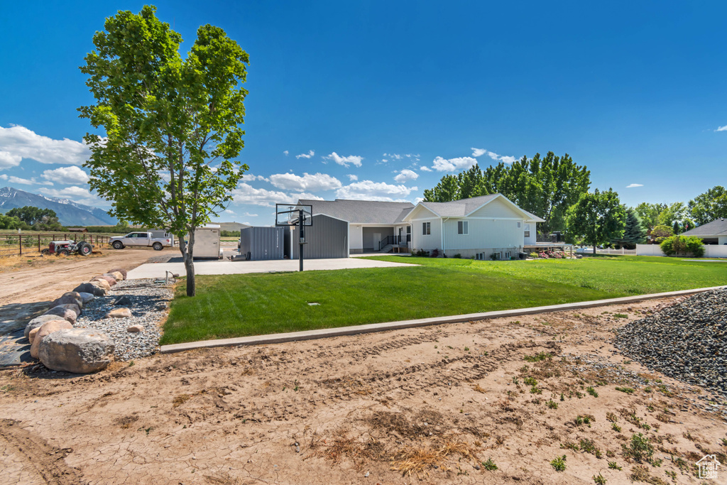 Back of house featuring a mountain view and driveway
