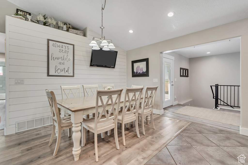 Dining space featuring recessed lighting, wood finished floors, baseboards, vaulted ceiling, and a chandelier