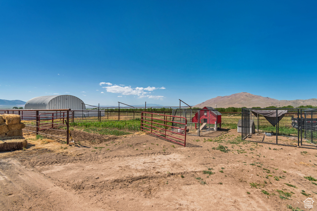 View of yard with an outdoor structure, a rural view, a detached garage, and a mountain view