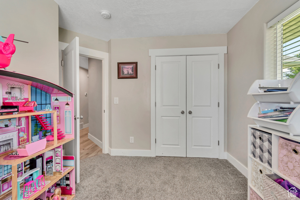 Recreation room featuring carpet flooring and baseboards