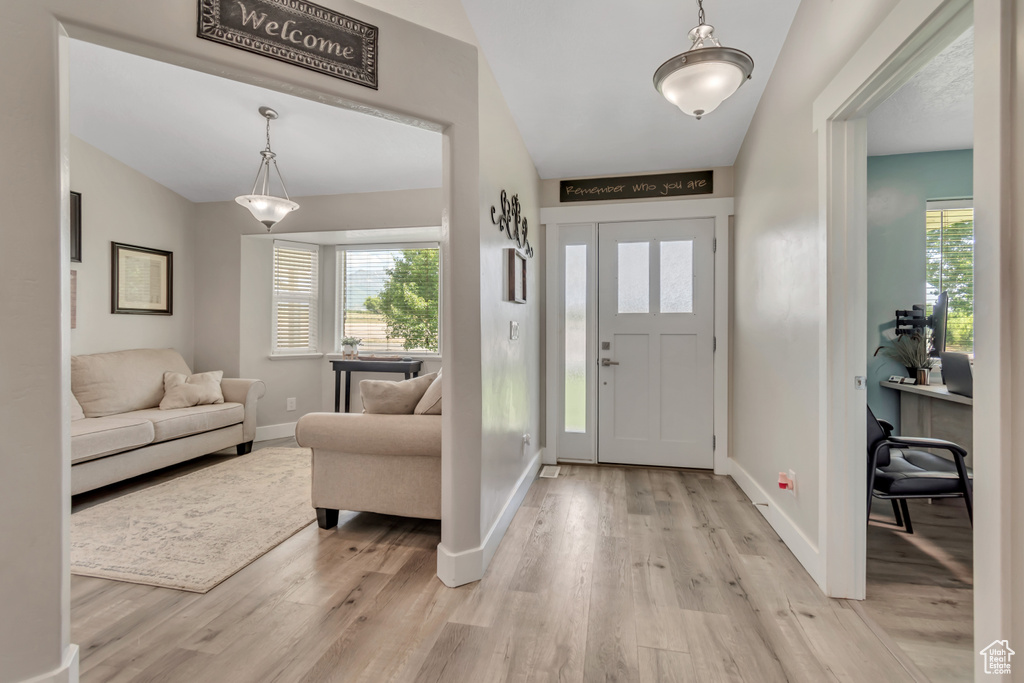 Foyer featuring light wood-style floors, healthy amount of natural light, and baseboards