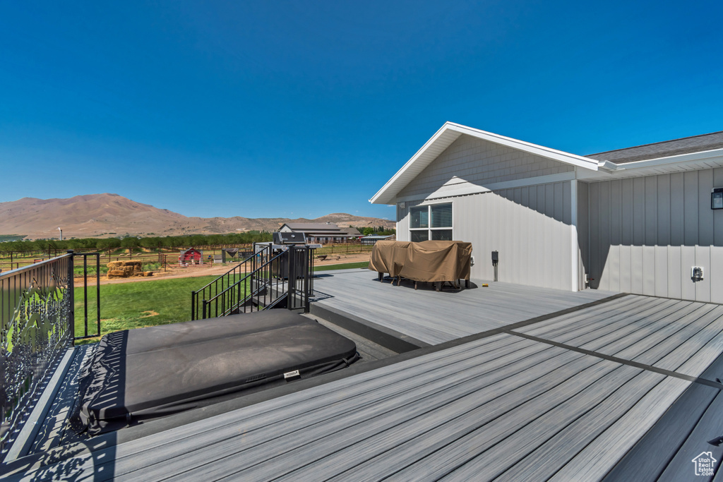 Wooden terrace featuring a mountain view and a lawn