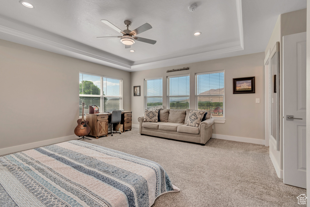 Bedroom with a raised ceiling, recessed lighting, light colored carpet, and baseboards
