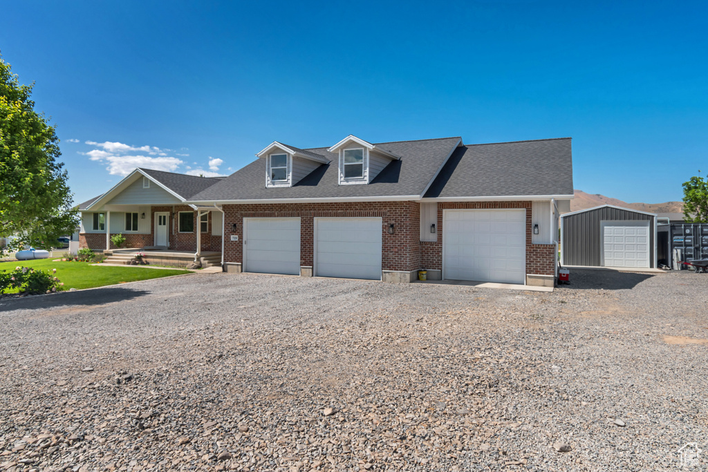 Townhome / multi-family property featuring brick siding, a porch, a shingled roof, and driveway