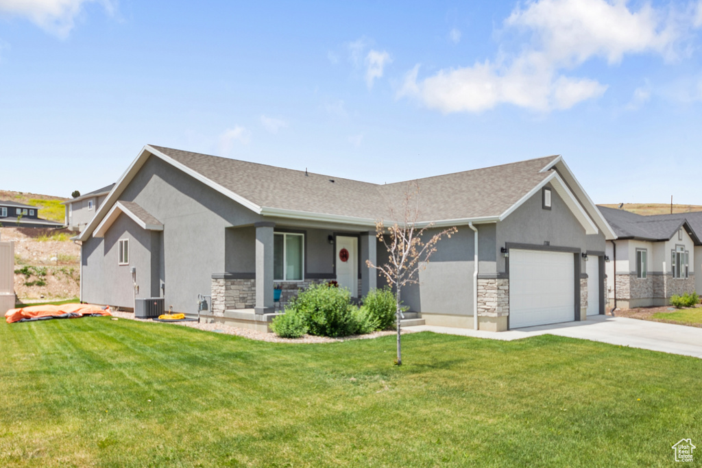 Ranch-style home with stucco siding, stone siding, a garage, concrete driveway, and a front yard