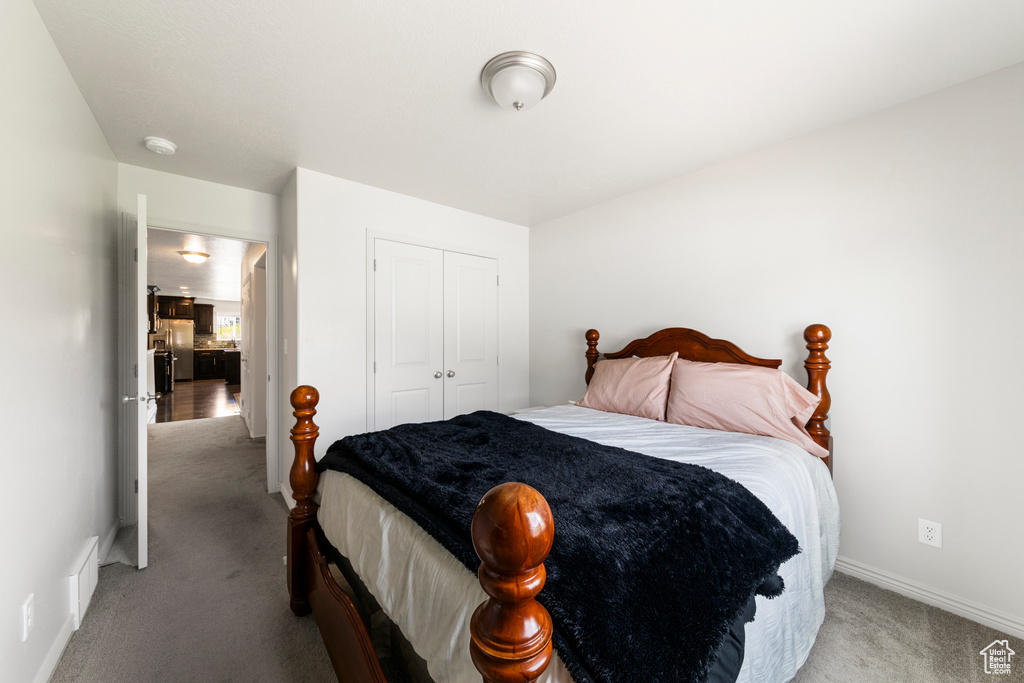 Bedroom featuring light colored carpet, a closet, and baseboards