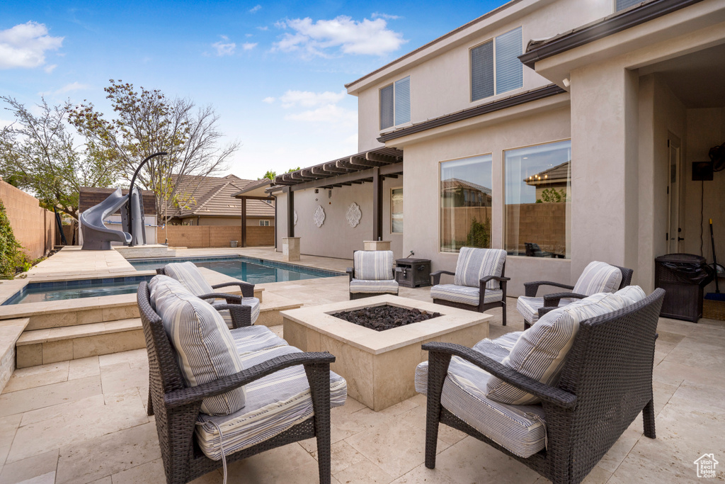Fenced backyard featuring an outdoor fire pit, a patio area, and an in-ground hot tub