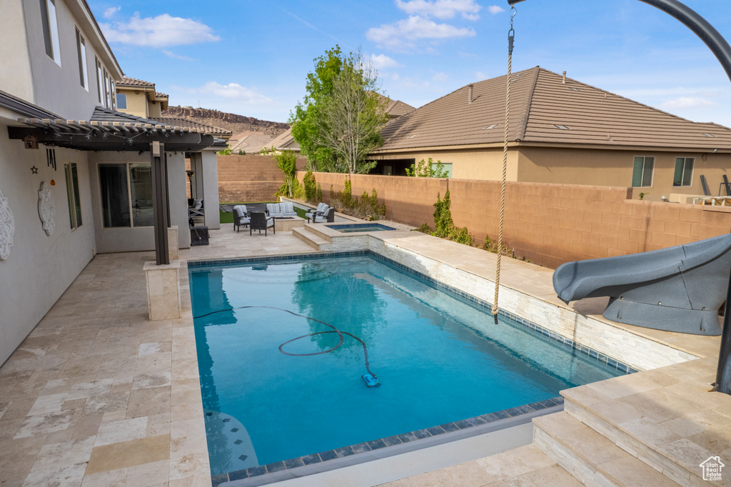 View of swimming pool featuring a fenced backyard, a pergola, a water slide, and a patio
