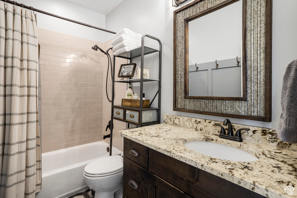 Full bathroom with shower / bath combo, vanity, and toilet