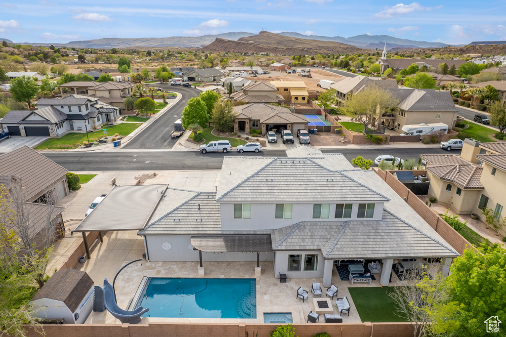 Aerial view of residential area featuring a pool area and a mountainous background
