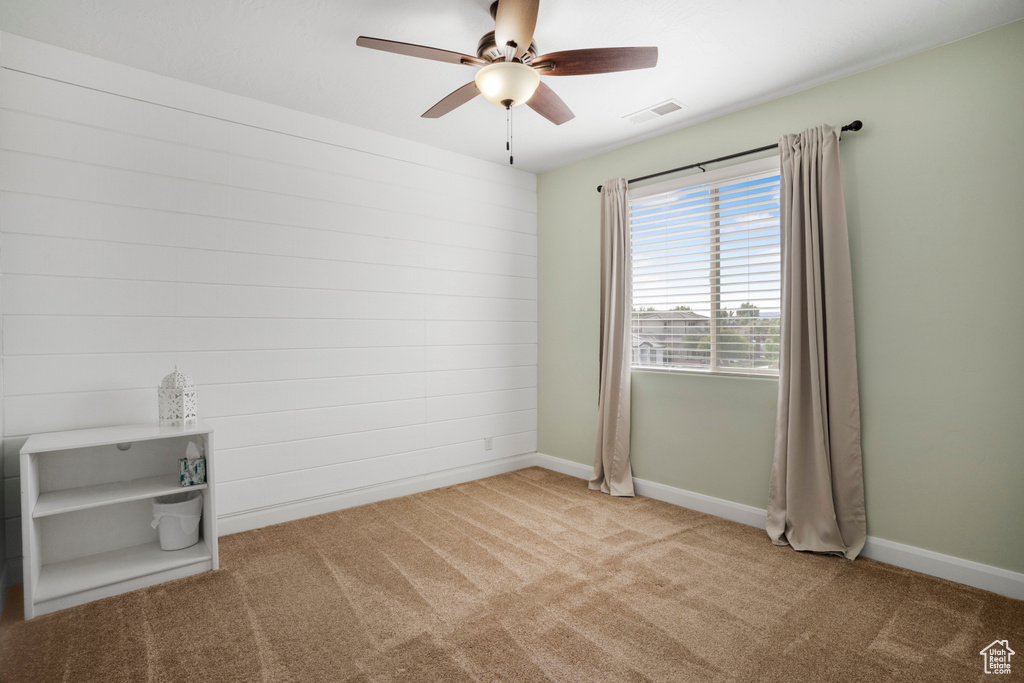 Empty room with carpet, a ceiling fan, and baseboards