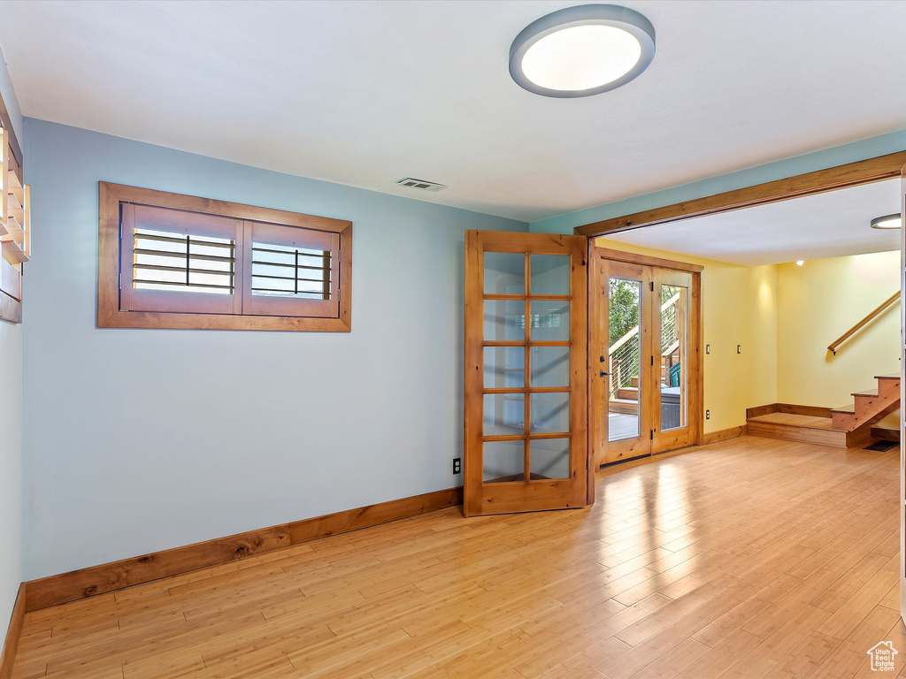 Spare room with baseboards, stairs, wood finished floors, and french doors