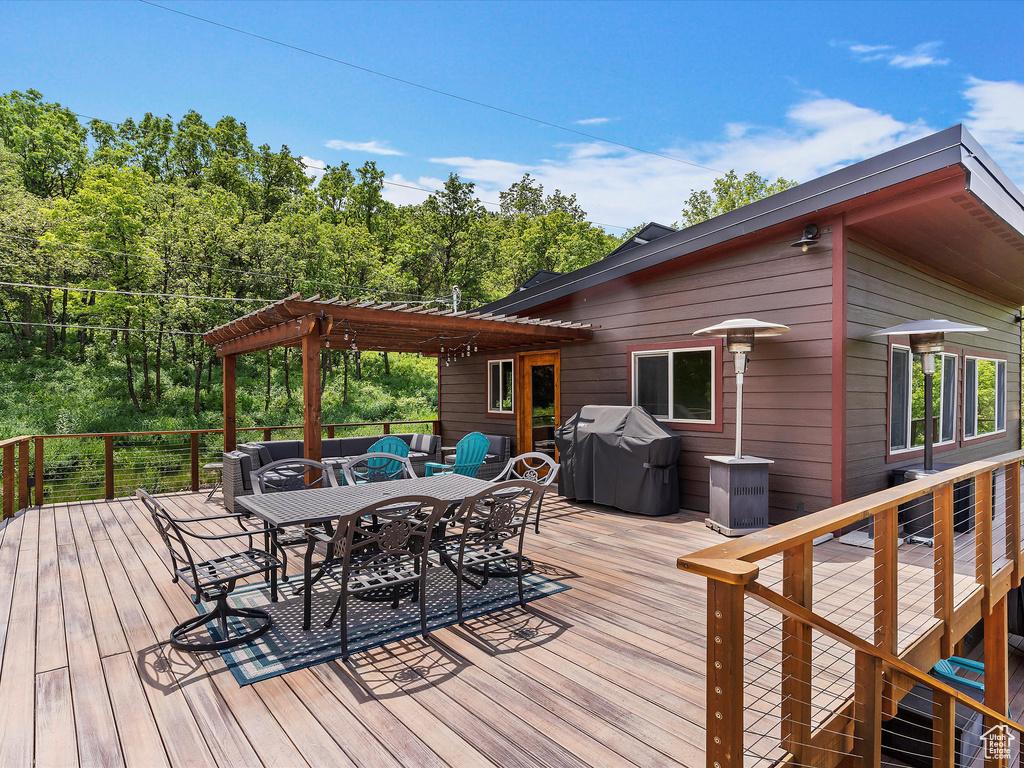 Wooden terrace with outdoor dining space and grilling area