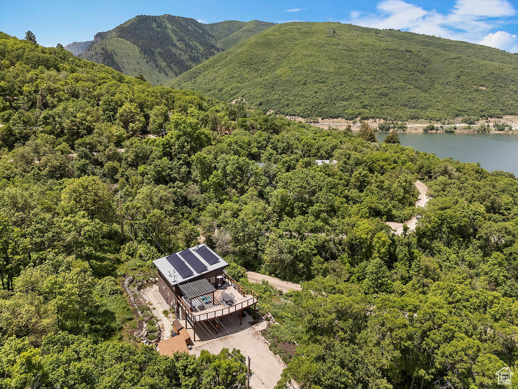 View from above of property with a forest and a water and mountain view