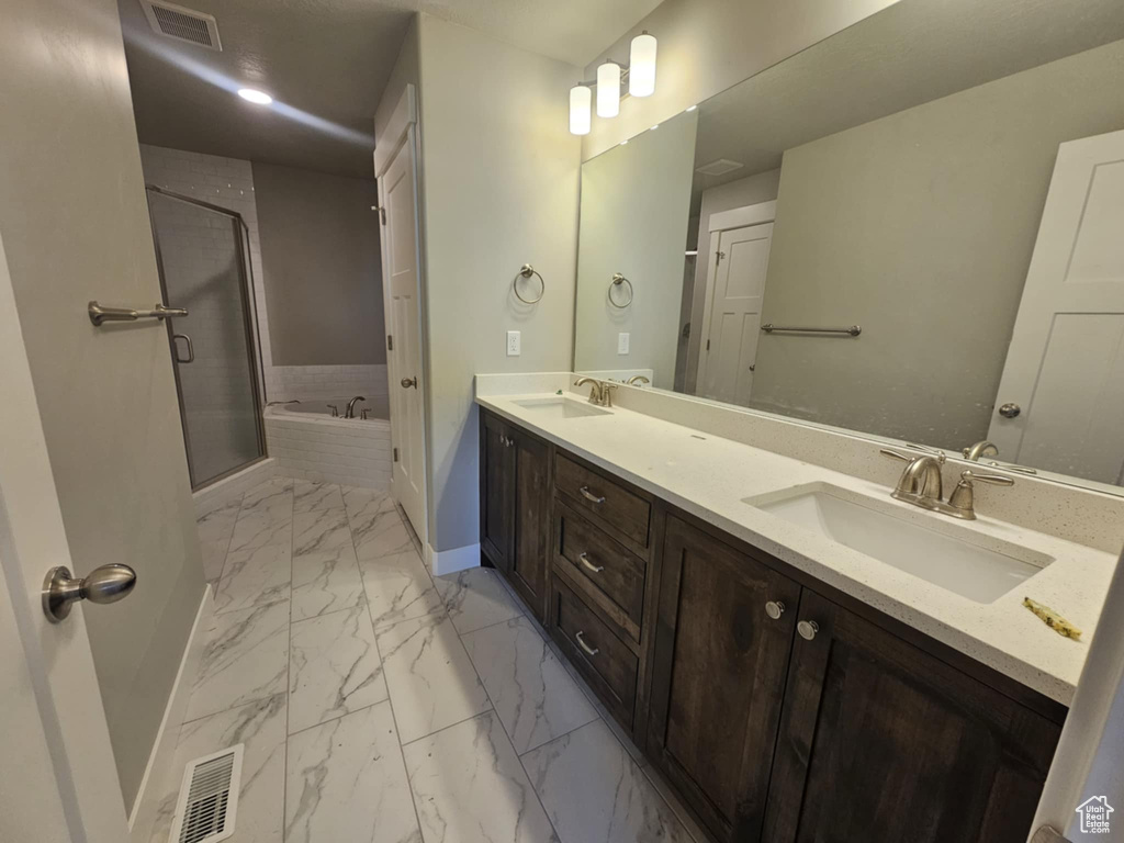 Bathroom with marble finish floors, baseboards, a garden tub, double vanity, and a shower stall