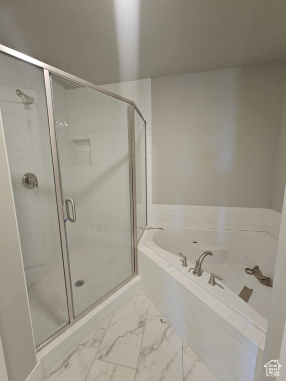 Full bath featuring a bath, a stall shower, and marble finish floors