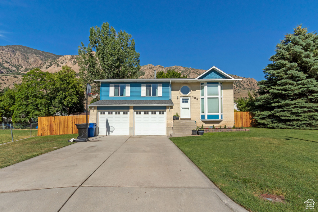 View of front of house with driveway, a mountain view, and a garage