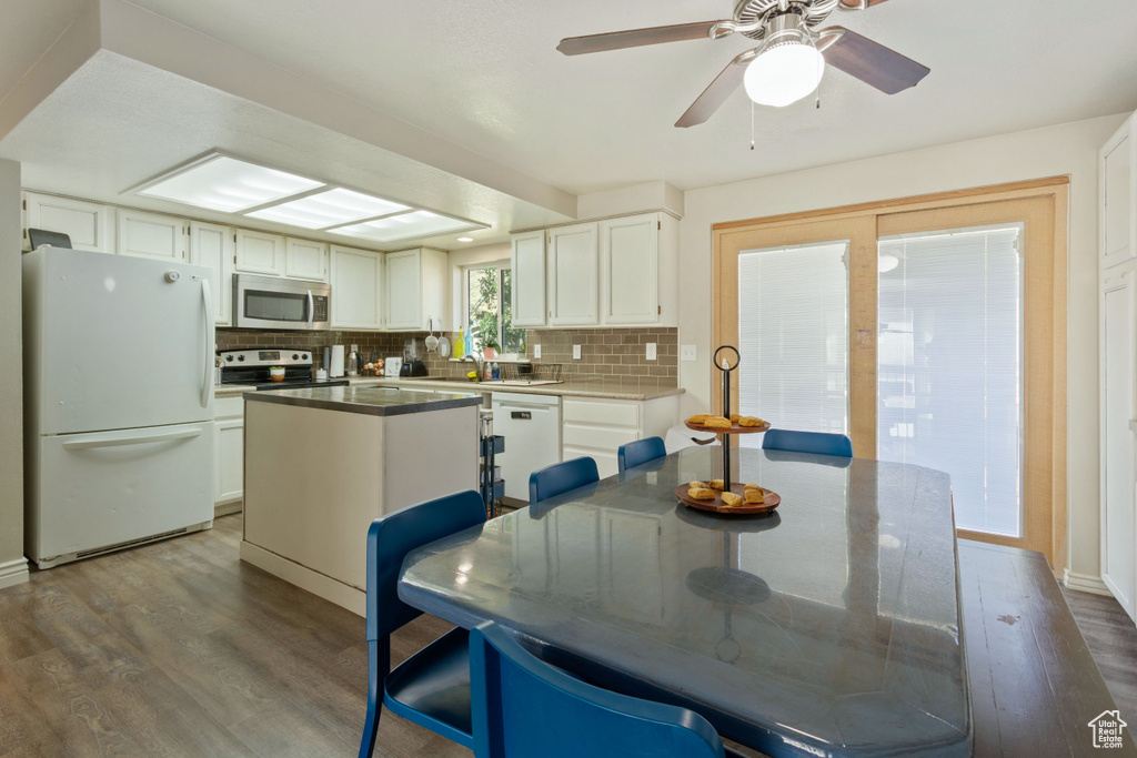 Dining area with dark wood-type flooring and a ceiling fan