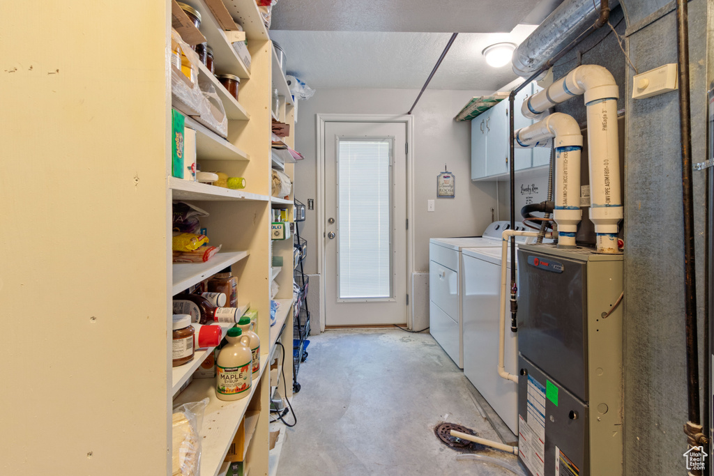 Washroom featuring separate washer and dryer and cabinet space