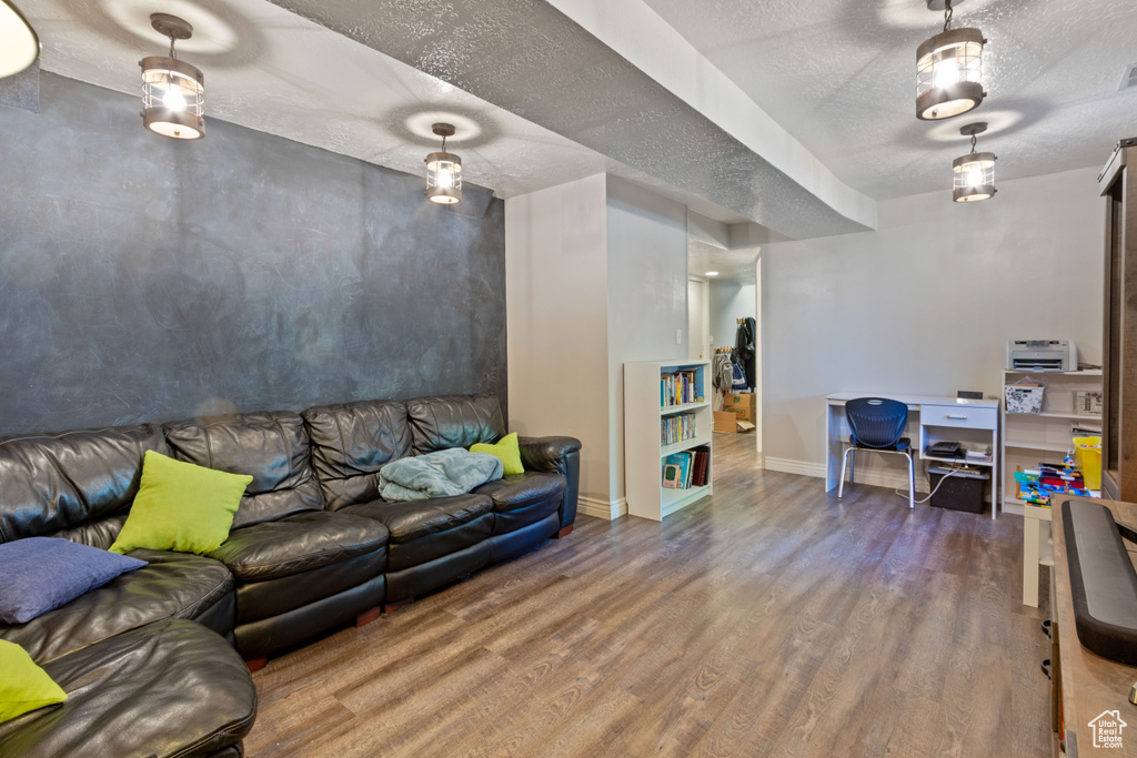 Living area with wood finished floors, baseboards, and a textured ceiling