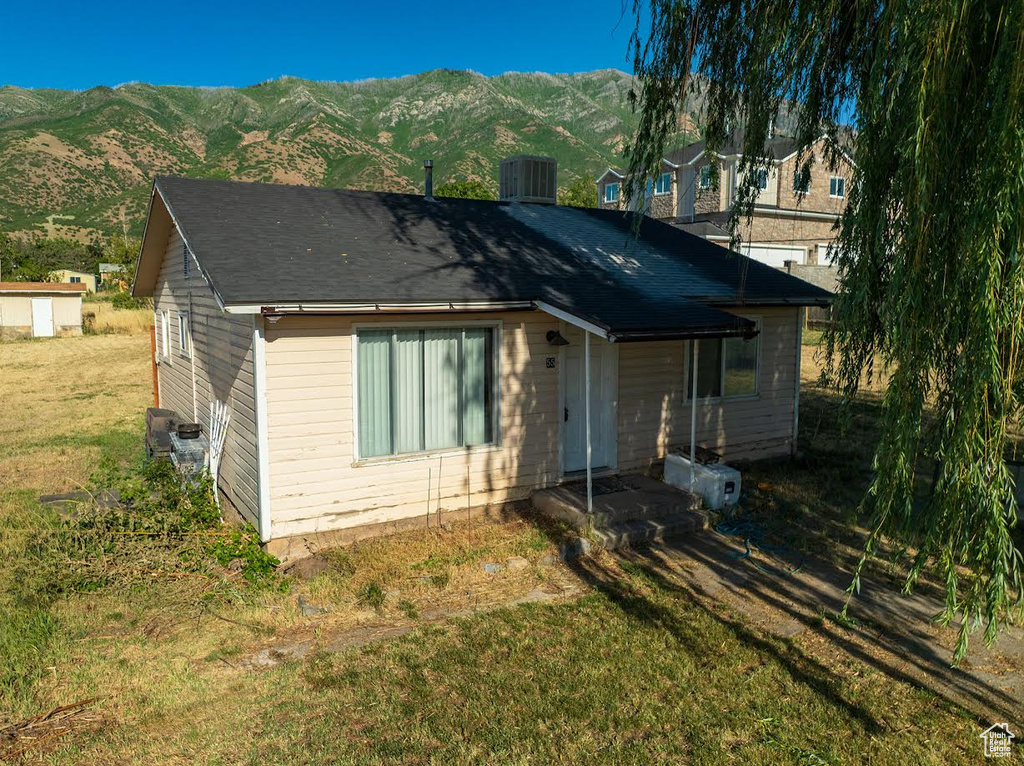 View of front of property with a mountain view and a front yard
