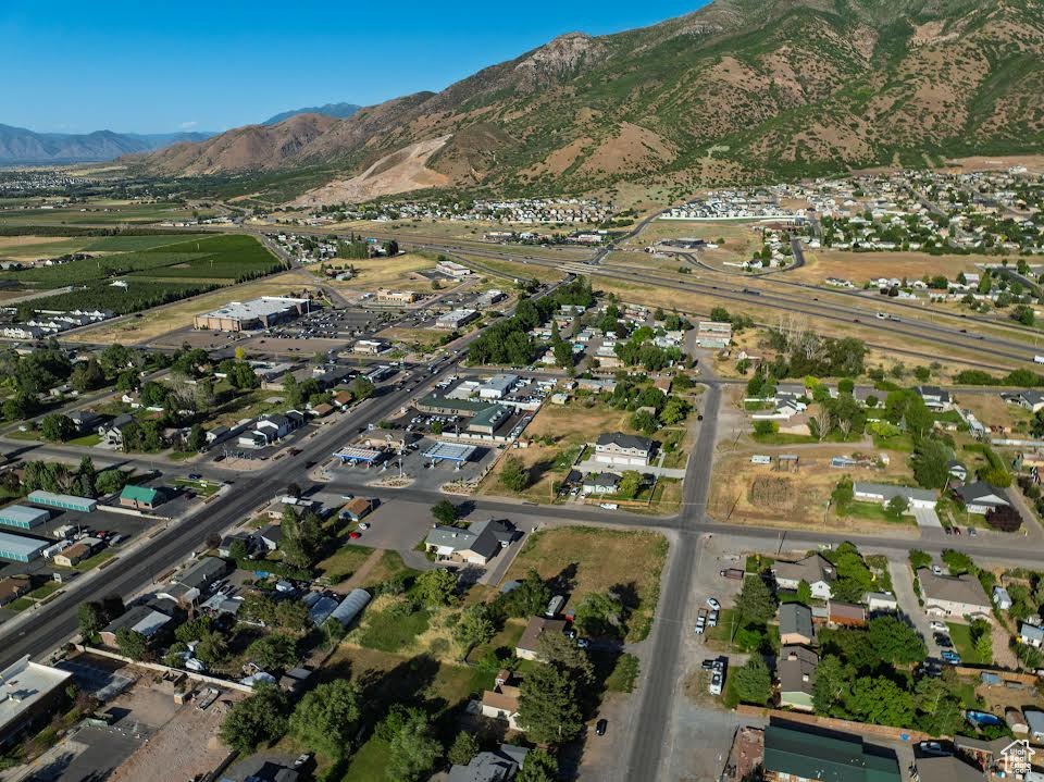 Aerial view of property and surrounding area featuring a mountain backdrop