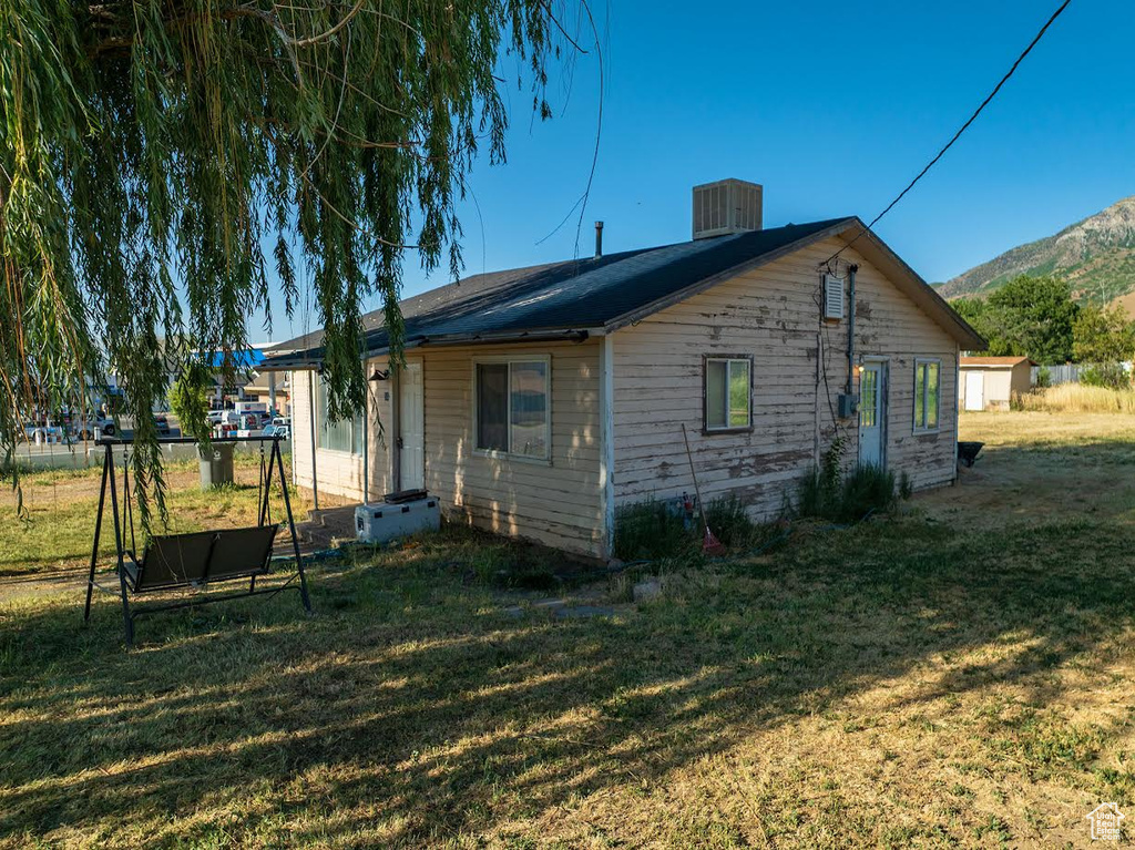 Rear view of property featuring a yard and a mountain view