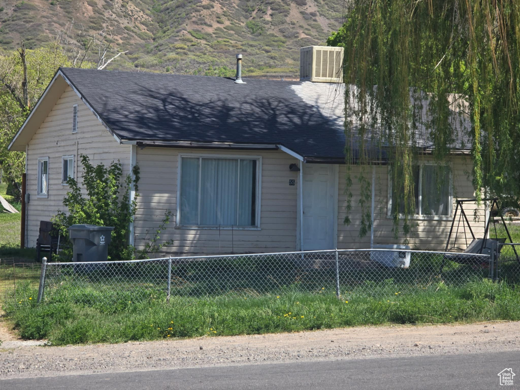 View of front of property featuring a fenced front yard and a mountain view