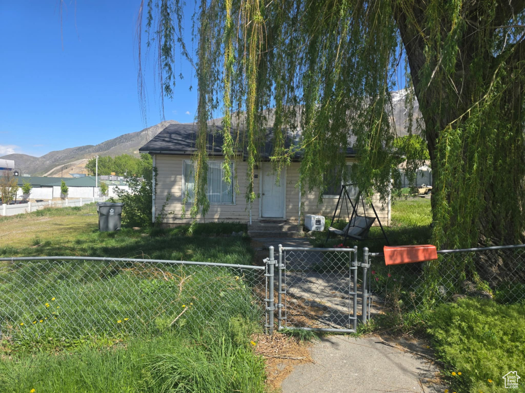 View of front facade with a fenced front yard, a gate, and a mountain view