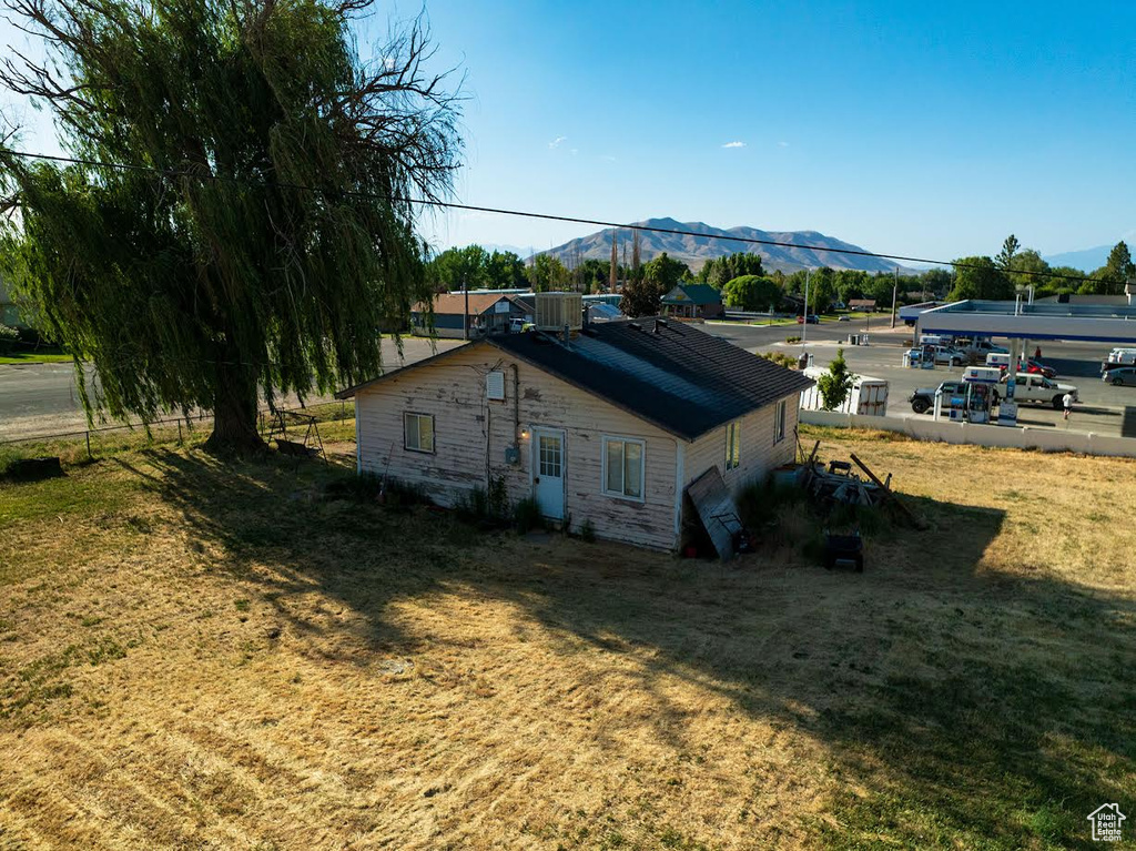 View of home's exterior with a mountain view and a yard