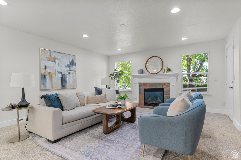 Living area featuring carpet flooring, baseboards, recessed lighting, and a tiled fireplace