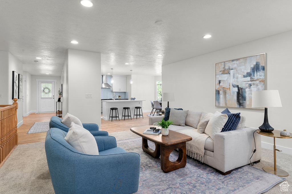 Living room with recessed lighting, light wood finished floors, and baseboards