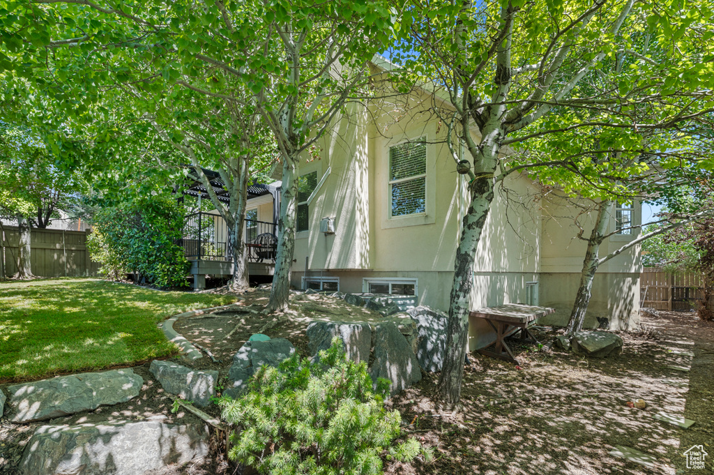 View of side of property with a wooden deck and stucco siding