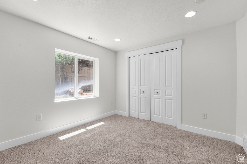 Unfurnished bedroom featuring carpet flooring, recessed lighting, a closet, and baseboards