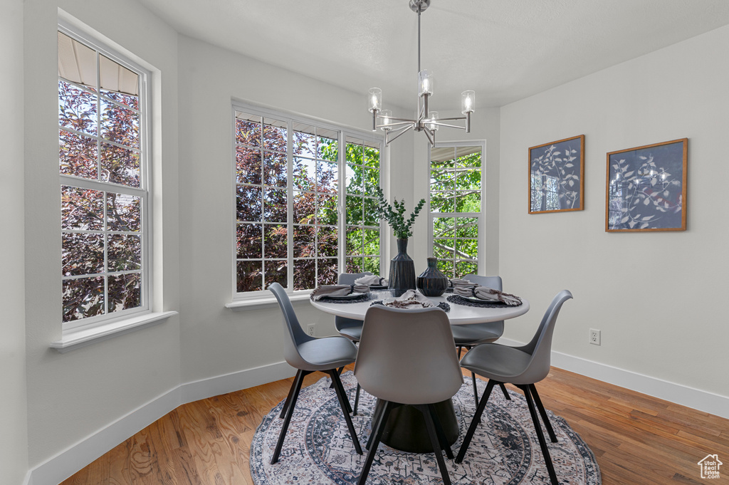 Dining area with a chandelier, baseboards, and wood finished floors