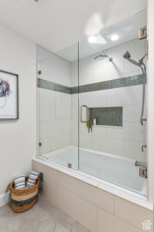 Full bath featuring tiled shower / bath combo and tile patterned floors