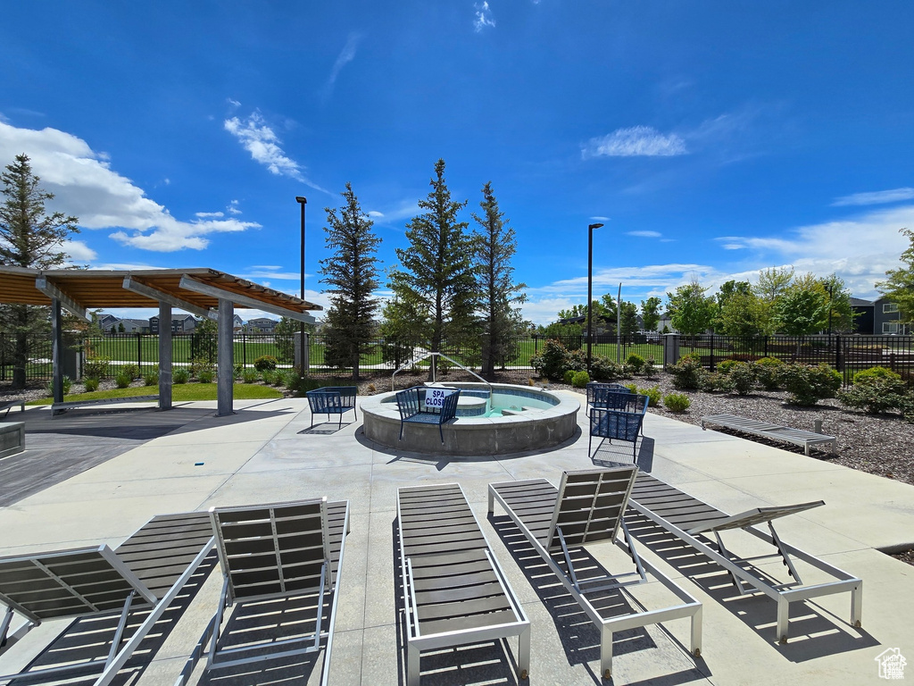 View of swimming pool with a patio area and an in-ground hot tub