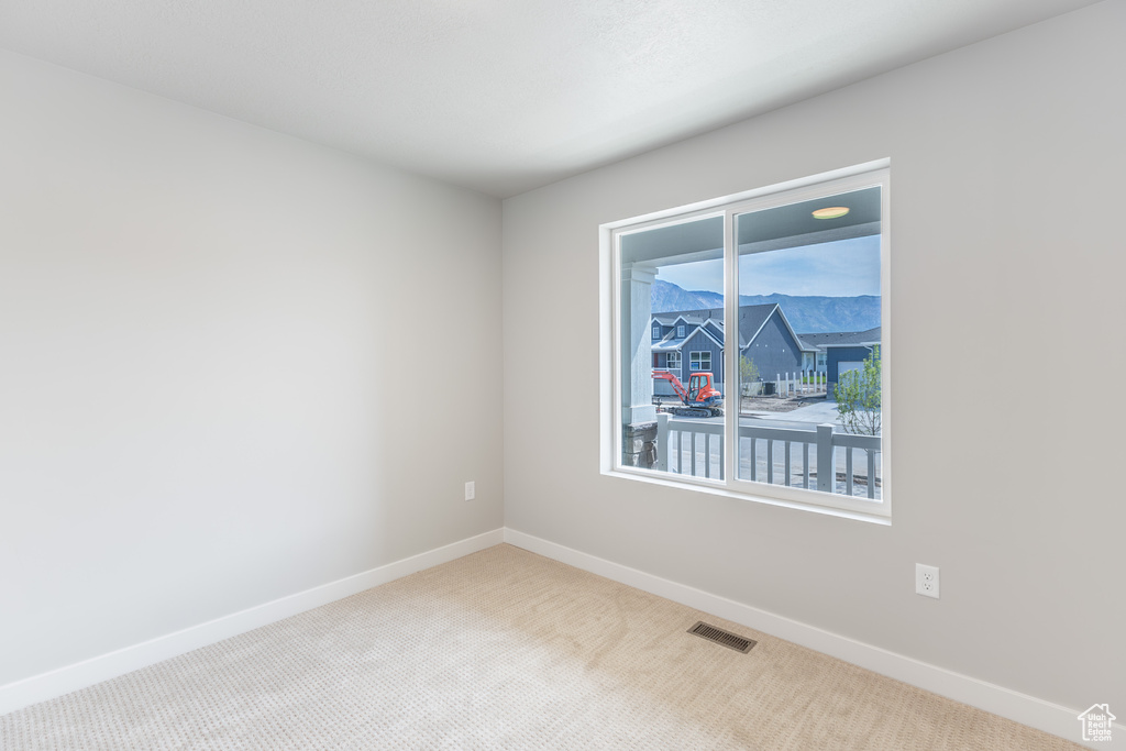 Unfurnished room featuring carpet and baseboards