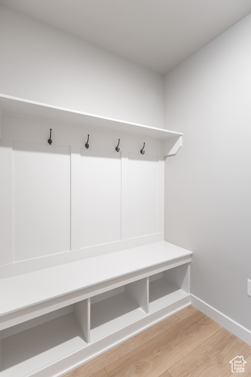 Mudroom with light wood-style floors and baseboards