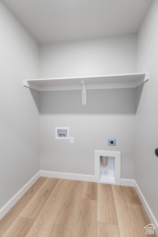 Laundry area with hookup for an electric dryer, wood finished floors, hookup for a washing machine, and baseboards