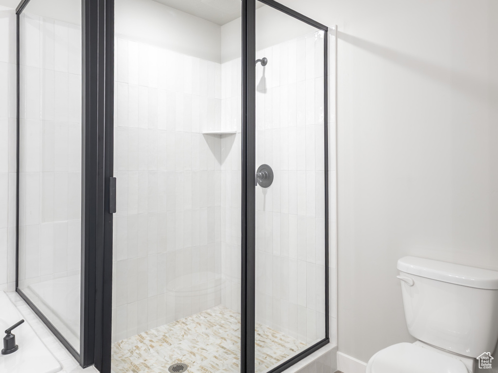 Full bath featuring a shower stall, toilet, and tile patterned flooring
