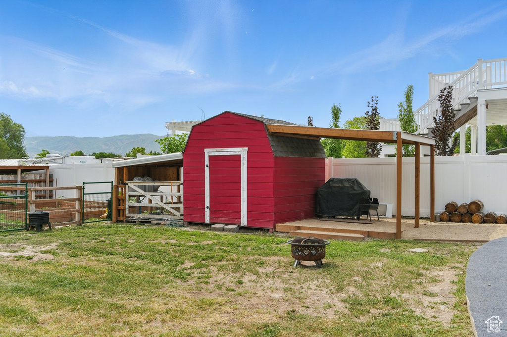 View of shed with an outdoor fire pit and a mountain view