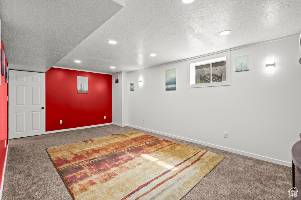 Finished basement with carpet floors, a textured ceiling, recessed lighting, and baseboards