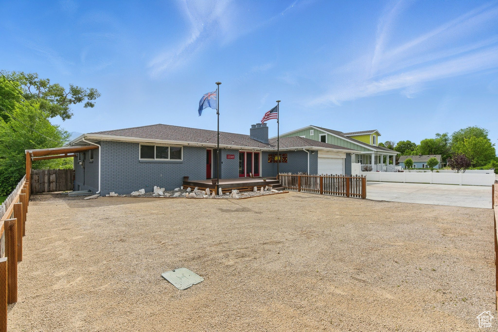 View of front of property featuring driveway, a garage, and brick siding